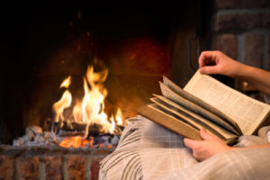 person-reading-a-book-by-the-fire