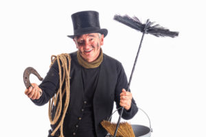 traditional chimney sweep in black clothign with hat and sweeping brush