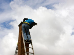 man on ladder next to chimney